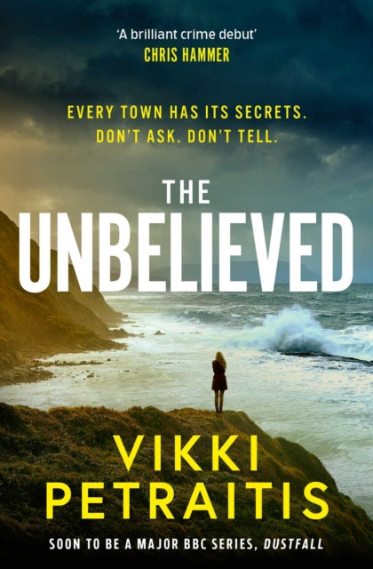 Book cover of 'The Unbelieved' by Vikki Petraitis with a person on a cliff overlooking the ocean.