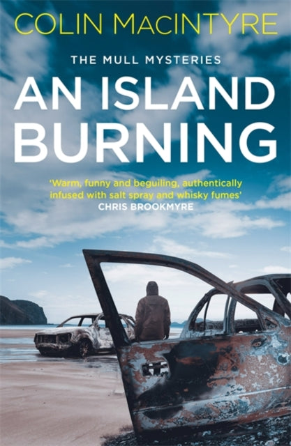 Book cover of 'An Island Burning' by Colin MacIntyre with a beach and wrecked car scene.