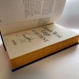An open hardcover book titled "Death Writ Large" by Susie Dent, signed.